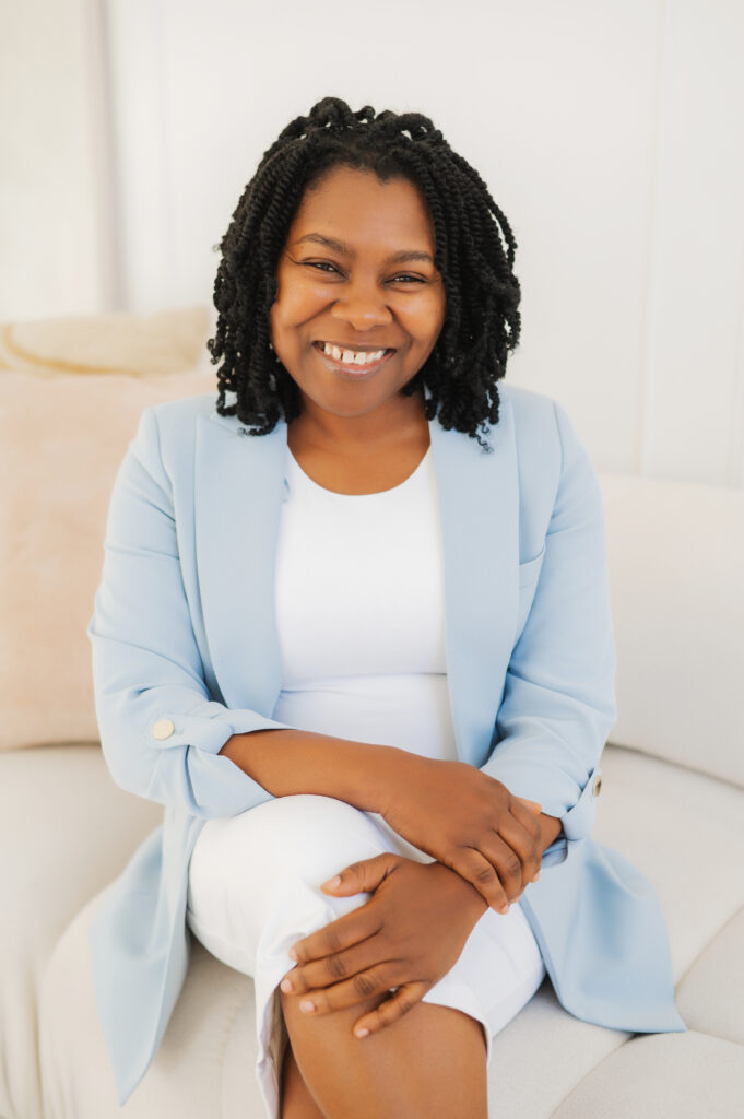 A photo of Johaine Thomas-Miranjie sitting on a chair